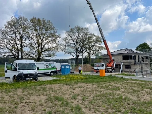 Baustelle mit Kran, davor Firmenwagen von Frankenland Fenster
